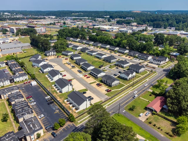 Aerial view of a suburban neighborhood with apartment buildings and houses.