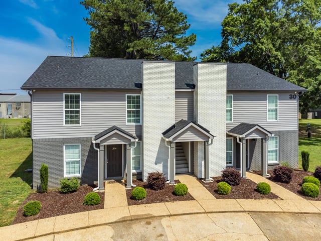Exterior view of a multifamily building with two entrances and manicured landscaping.