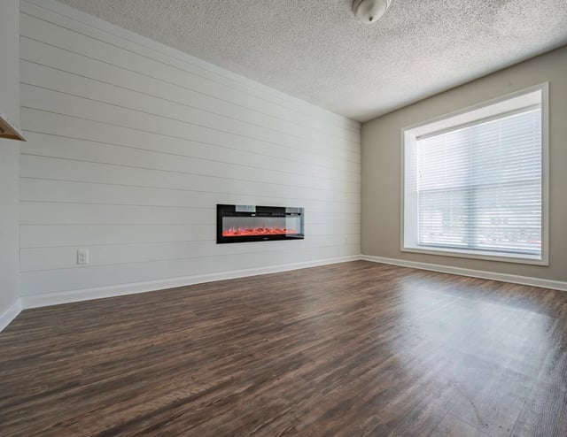 Empty living room with a fireplace and a large window