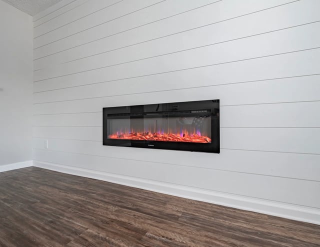 Modern electric fireplace with realistic flame effect mounted on a white shiplap wall.