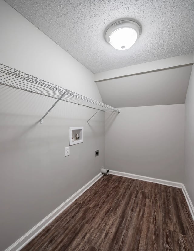 Empty laundry room with hookups and shelving.