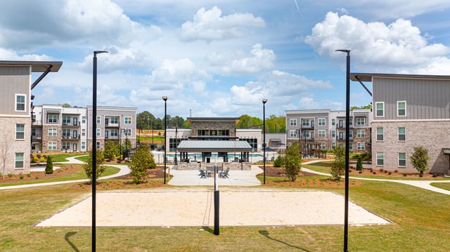 Apartment complex courtyard with pool and volleyball court.