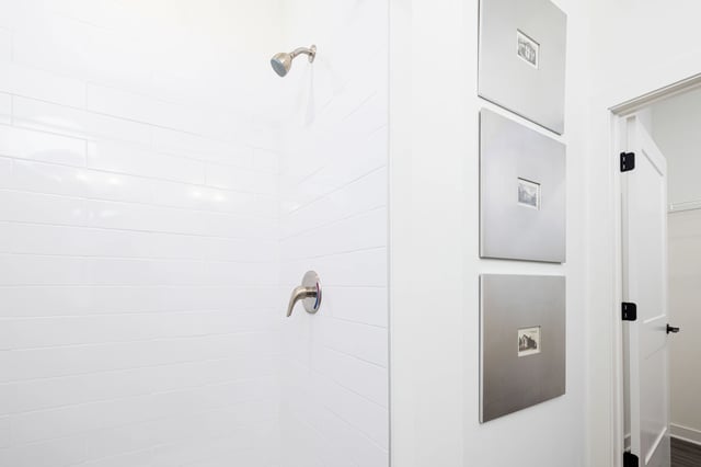 Modern bathroom with white subway tile shower and decorative wall art.