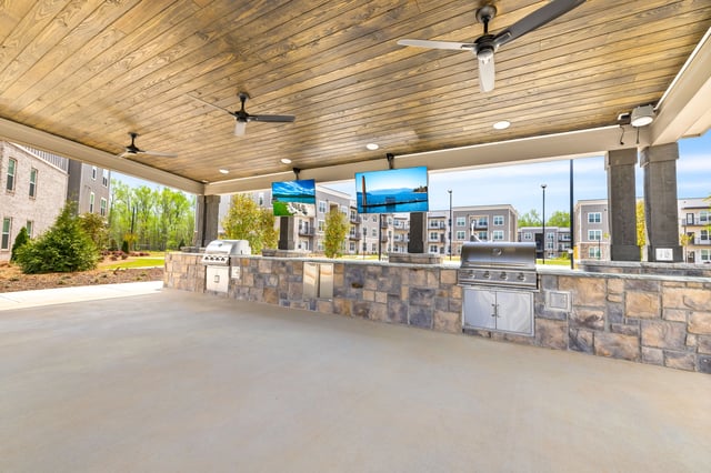 Covered outdoor kitchen with grills and televisions