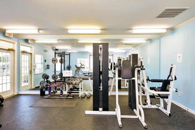 Gym with weight racks, treadmills, and weight machines.