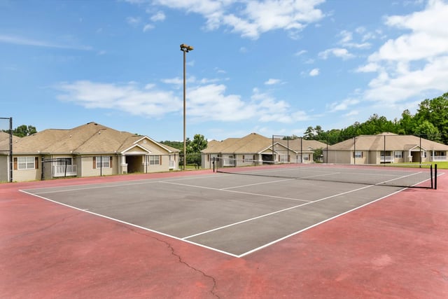 Tennis court with apartment buildings in the background
