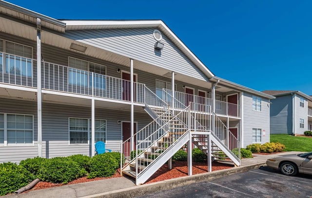 Exterior view of apartment buildings with white stairs and balconies.