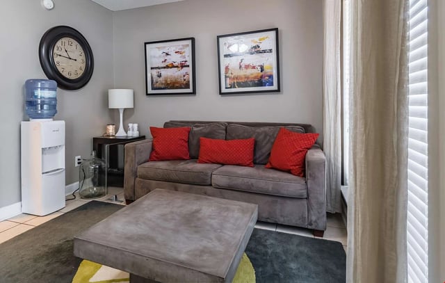Living room with a gray couch, coffee table, and water cooler.