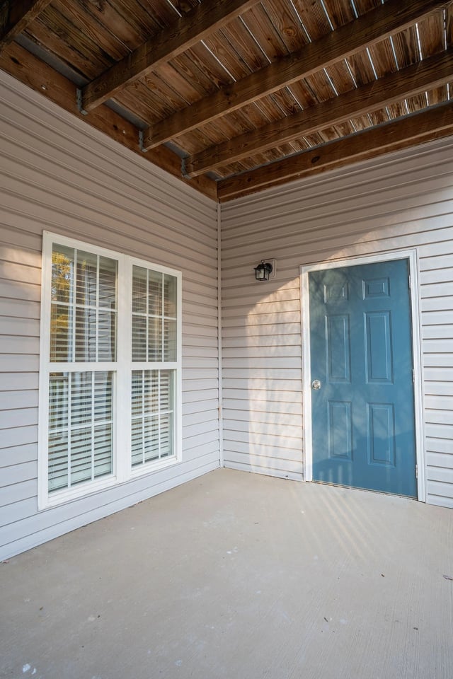 Exterior view of an apartment building entrance with a blue door and a window.