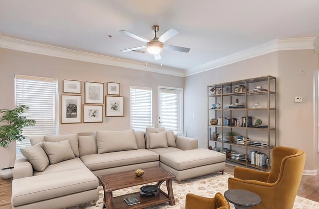 Spacious living room with a large sectional sofa, coffee table, and a bookshelf filled with books.