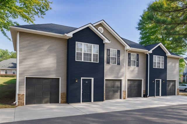 Exterior view of multi-unit apartment building with attached garages.