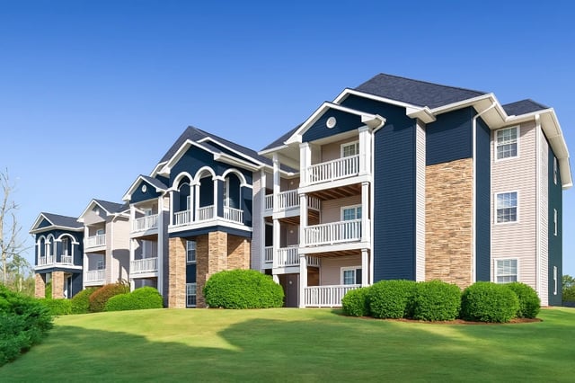 Exterior view of apartment buildings with balconies under a clear blue sky.