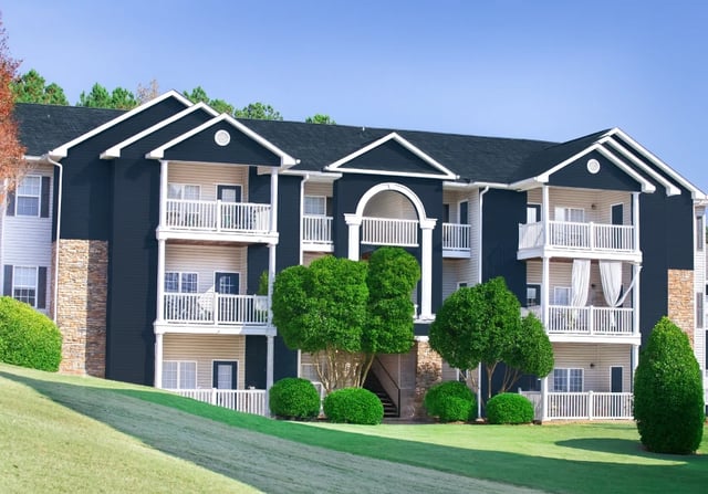 Exterior of an apartment building with balconies and landscaping.