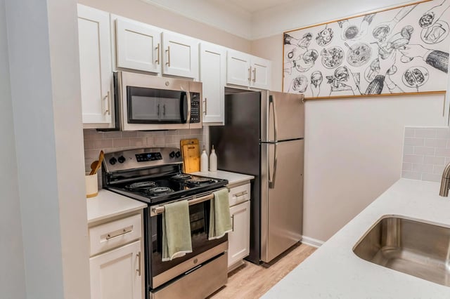 Kitchen with stainless steel appliances, white cabinets, and a subway tile backsplash.