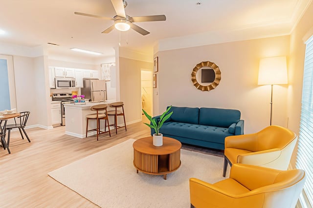 Living room and kitchen area of an apartment with modern furniture.