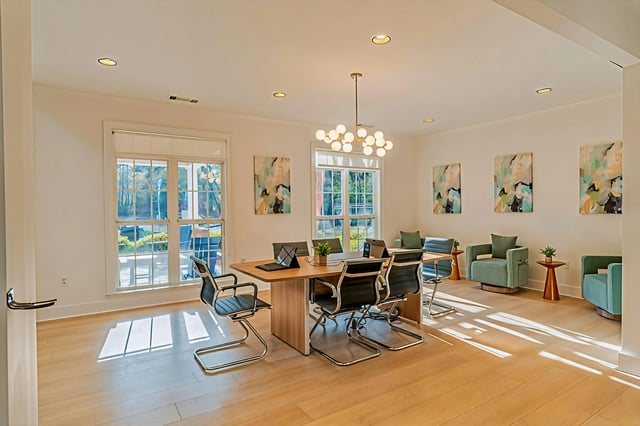 Bright and airy business center with comfortable seating and a large conference table.