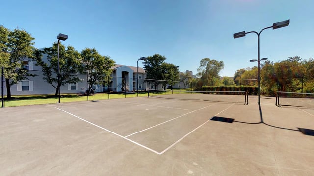 Tennis courts with apartment buildings in the background.