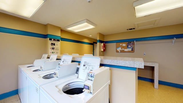 Laundry room with multiple washing machines and dryers.