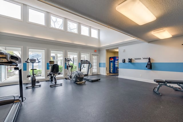 Fitness center with treadmills, stationary bikes, and weight benches.
