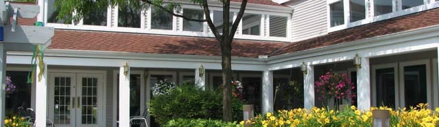 Exterior view of a building entrance with double doors and surrounding landscaping.