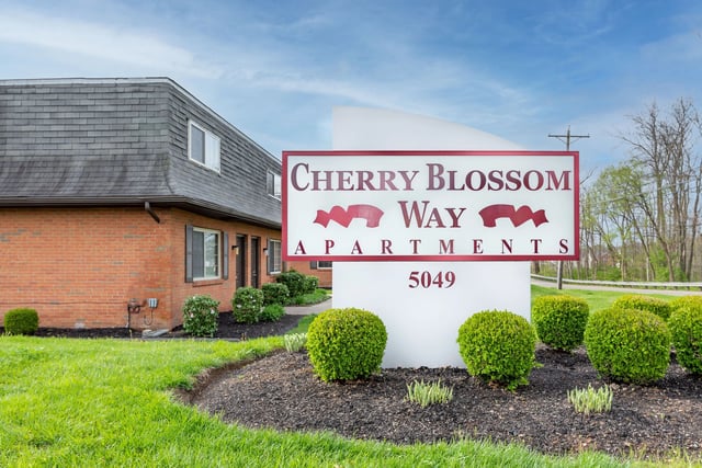 Cherry Blossom Way Apartments monument sign with building exterior.