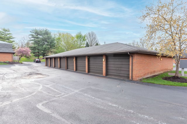 Garages with dark brown doors and brick exteriors.