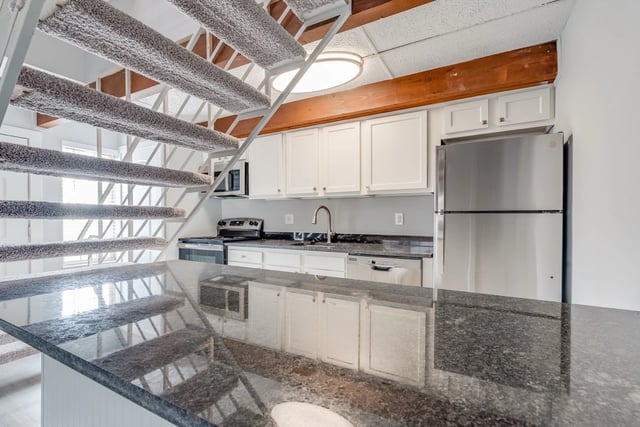 Kitchen with granite countertops, stainless steel appliances, and a breakfast bar.
