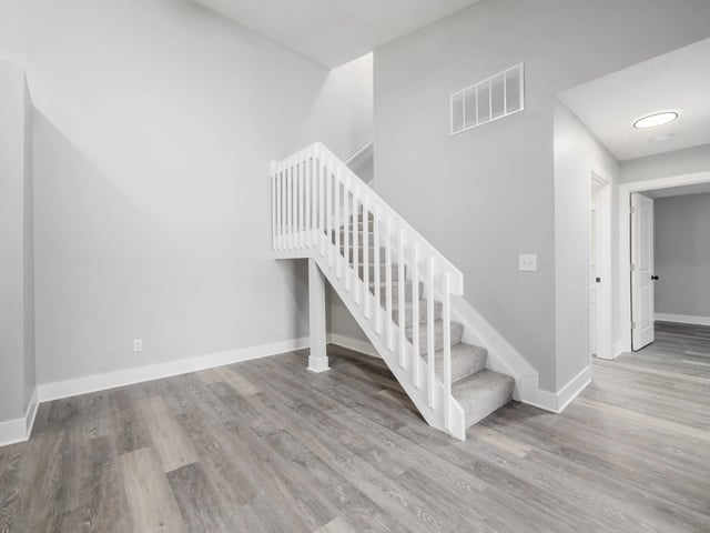 Interior view of a staircase in a neutral-colored apartment.