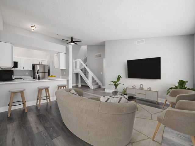 Modern open-concept living area with a kitchen island and breakfast bar.