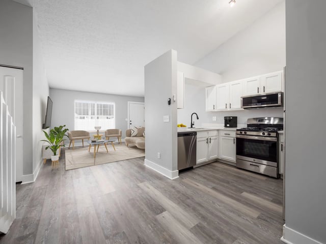 Open concept living and kitchen area with stainless steel appliances and modern finishes.