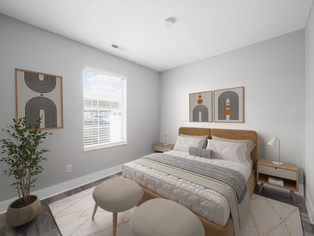 Modern bedroom with a queen-size bed, bedside tables, and minimalist art.