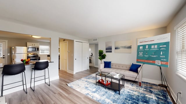 Open concept living room and kitchen with bar seating and modern decor.