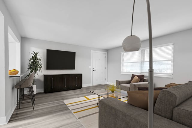 Spacious living room with a large TV, comfortable seating, and a breakfast bar.