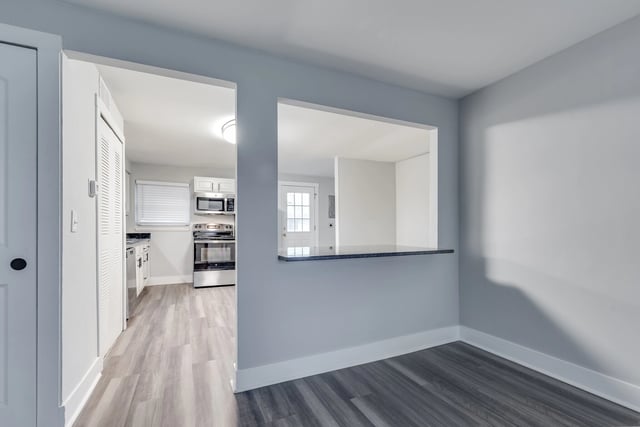 View of a kitchen and dining area with a pass-through.