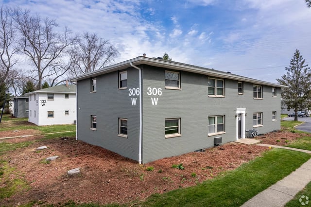Exterior view of the apartment building with gray brick and white trim.