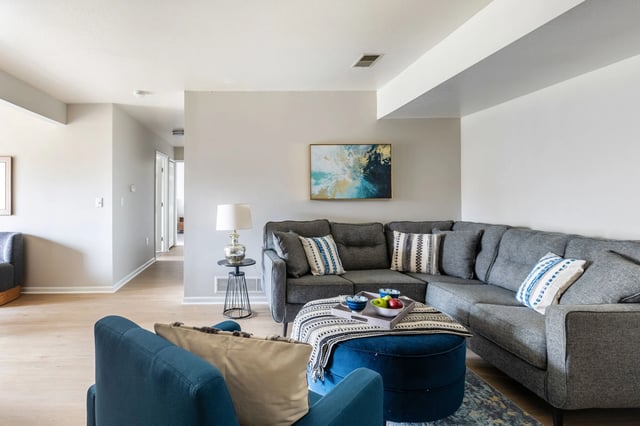 Modern living room with a sectional sofa, accent chairs, and a coffee table.