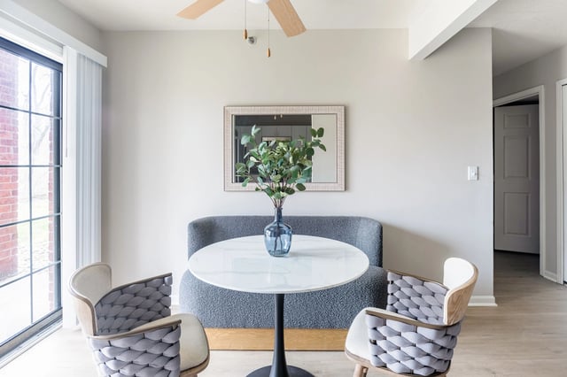 Dining area with two chairs, a table, and a sofa.