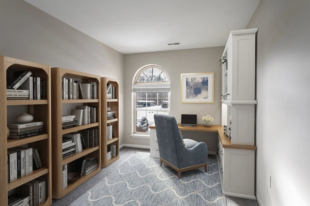 Home office with bookshelves, desk, and chair overlooking a snowy landscape.