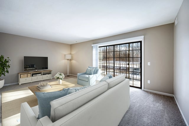 Living room with white sofa, armchair, coffee table, TV, and large window overlooking a snowy landscape.