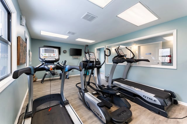 Treadmills and elliptical machines in a fitness center.
