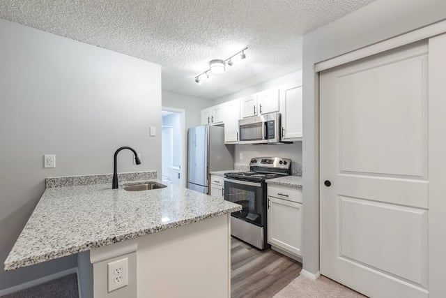 Modern kitchen with granite countertops and stainless steel appliances.