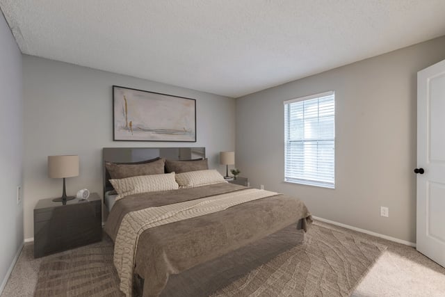 Bedroom with a king-size bed, nightstand, and a window.