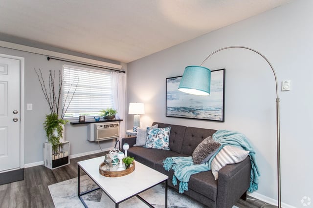 Living room with a dark gray sofa, a white coffee table, and a modern floor lamp.