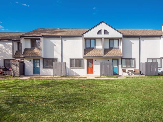 Exterior of apartment buildings with green grass in front.