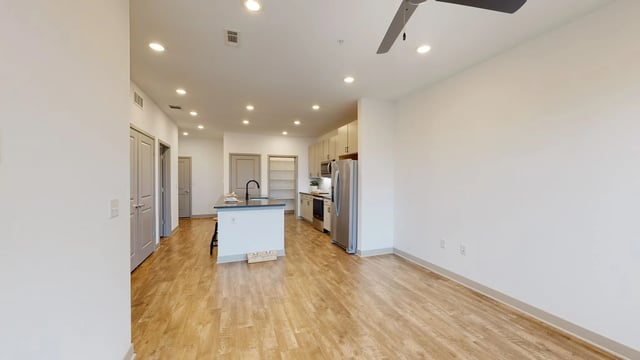 Open concept living area with kitchen island and stainless steel appliances