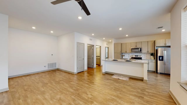 Open-concept living area and kitchen with modern finishes and stainless steel appliances.