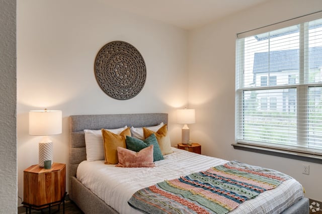 Bedroom with a queen-size bed, decorative wall art, and bedside lamps.