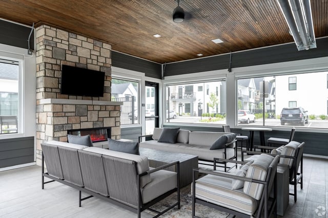 Communal lounge with fireplace, comfortable seating, and large windows overlooking the exterior.
