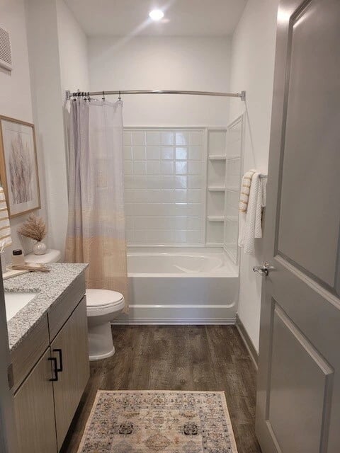 Bathroom vanity, toilet, and bathtub with shower curtain.