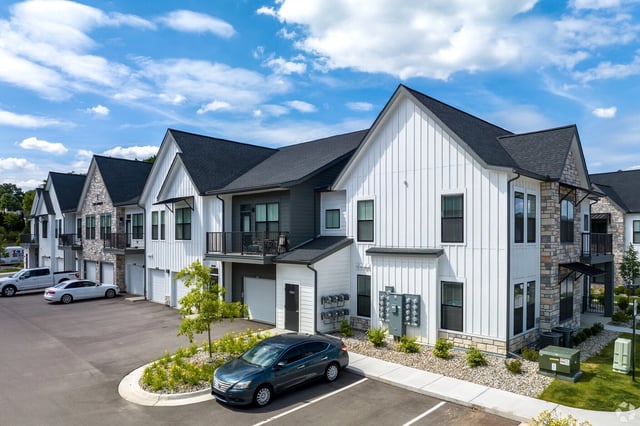 Exterior view of apartment buildings with garages and balconies.